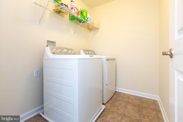 washroom with tile patterned flooring, laundry area, baseboards, and washer and clothes dryer