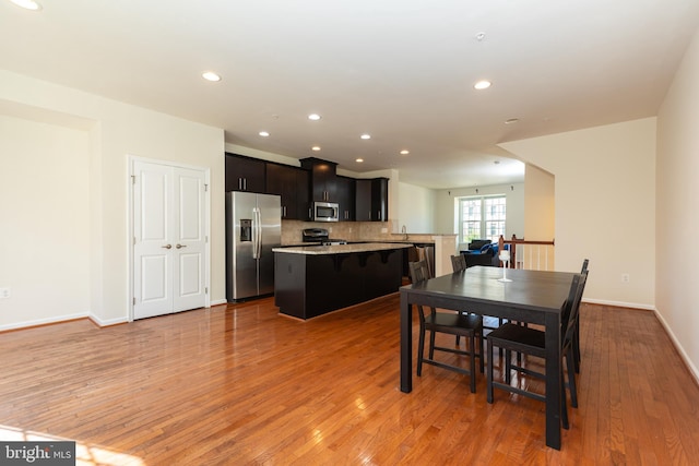 dining space featuring recessed lighting, baseboards, and light wood-style floors