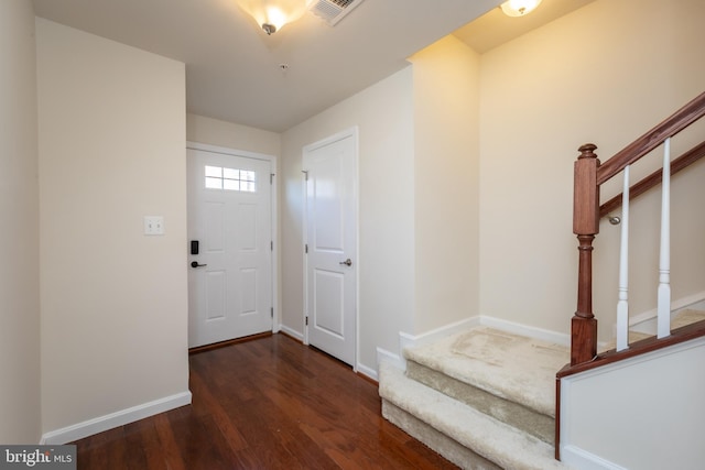 entryway with visible vents, baseboards, wood finished floors, and stairs