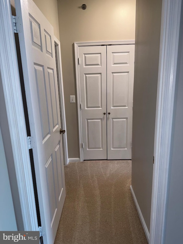 hall with carpet flooring and baseboards