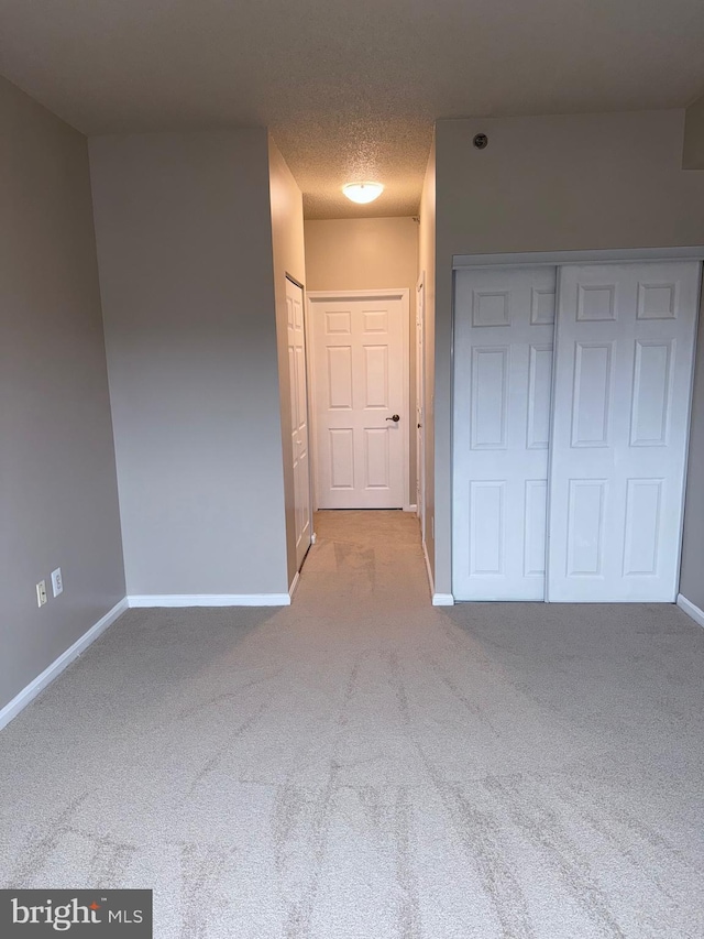 unfurnished bedroom with baseboards, carpet floors, and a textured ceiling