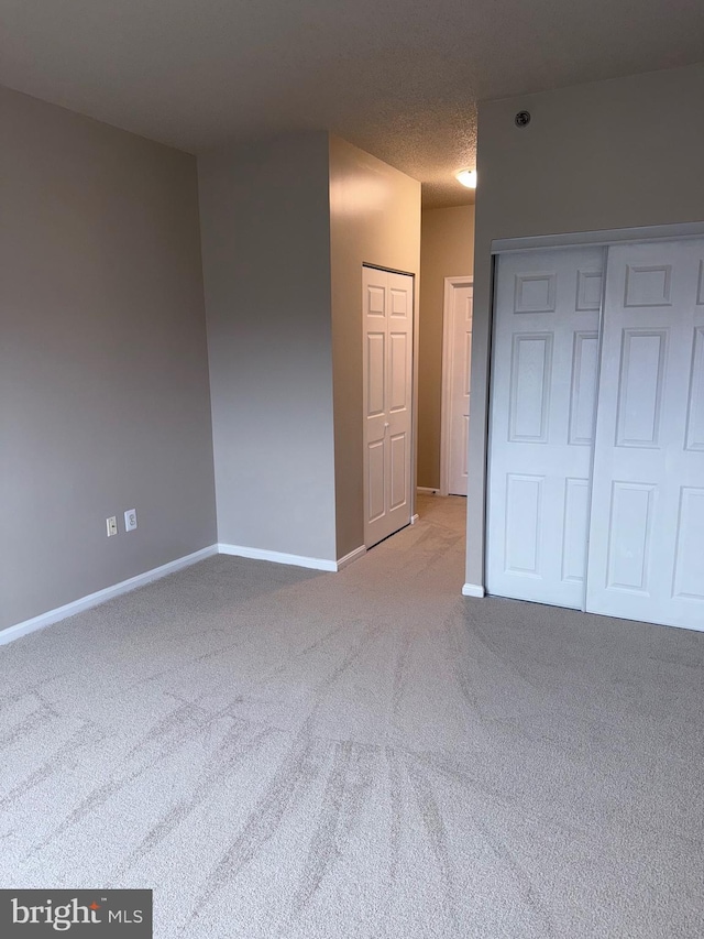 carpeted spare room with baseboards and a textured ceiling