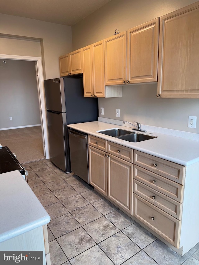 kitchen featuring a sink, dishwasher, light brown cabinetry, and light countertops