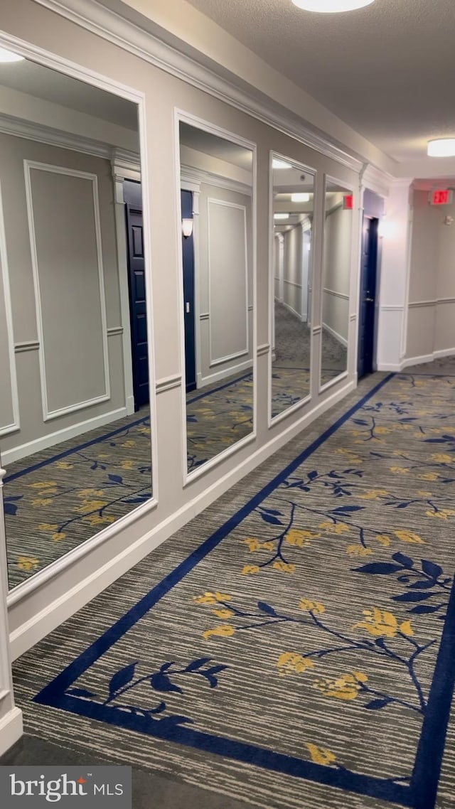 hall with crown molding and carpet