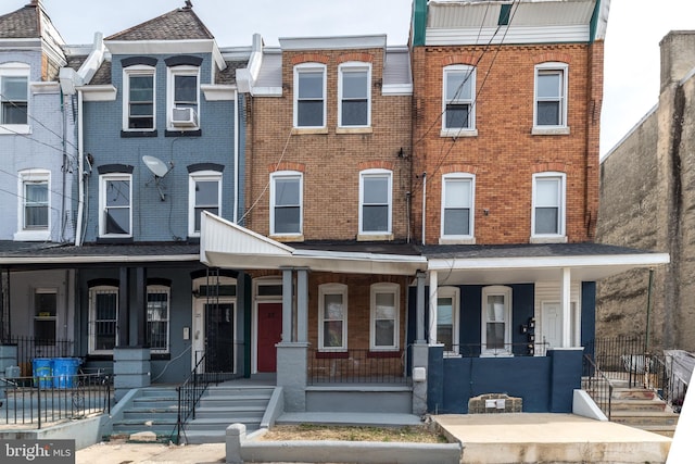 multi unit property featuring brick siding and a porch