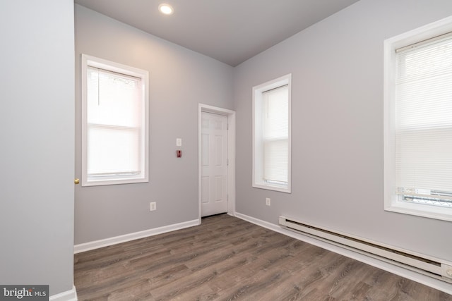 unfurnished room featuring recessed lighting, wood finished floors, baseboards, and a baseboard radiator