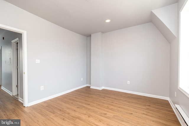 interior space featuring recessed lighting, a baseboard radiator, baseboards, and light wood-style flooring