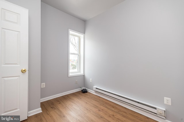 unfurnished room featuring light wood-style floors, baseboards, and baseboard heating