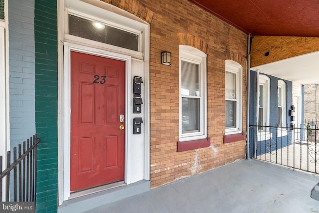 entrance to property featuring brick siding and a porch