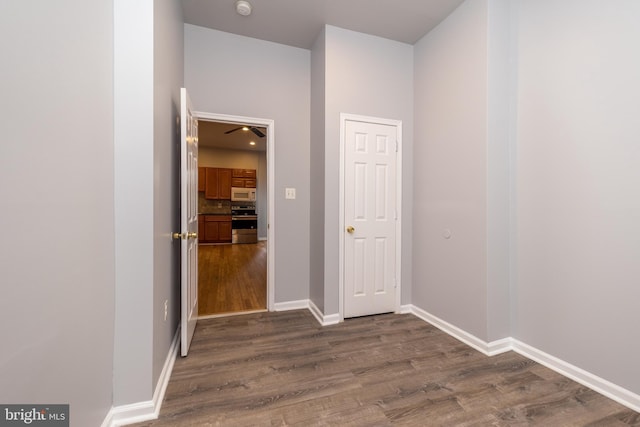 hall with baseboards and dark wood-style flooring