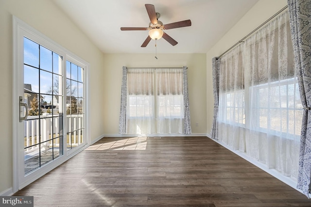 spare room with plenty of natural light, baseboards, ceiling fan, and wood finished floors