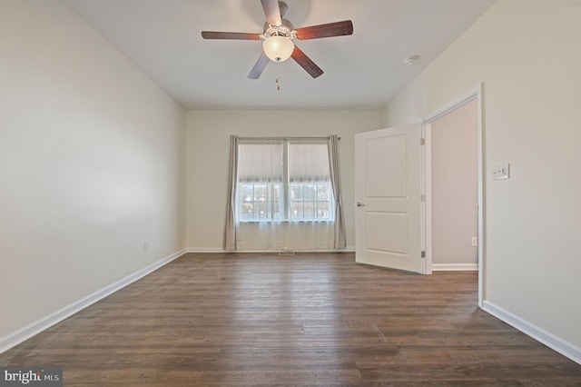 empty room featuring baseboards, a ceiling fan, and dark wood-style flooring