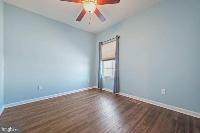 empty room with a ceiling fan, dark wood-type flooring, visible vents, and baseboards