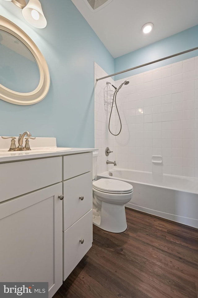 bathroom with toilet, vanity, shower / bathing tub combination, and wood finished floors