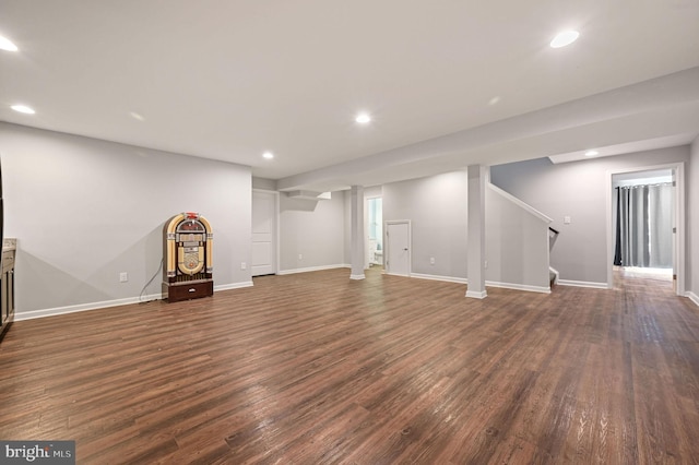 finished below grade area featuring recessed lighting, stairway, baseboards, and dark wood-type flooring