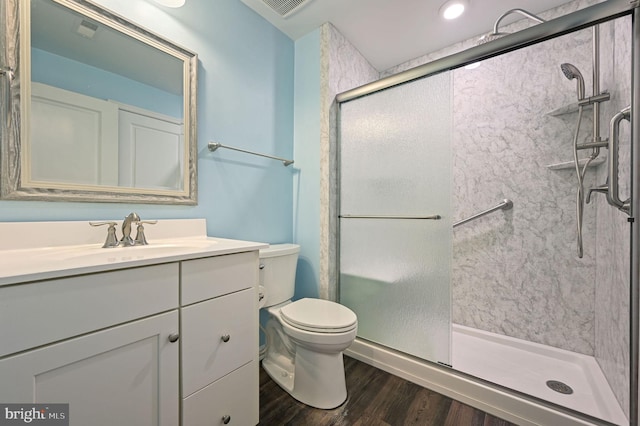 full bath with a shower stall, toilet, vanity, and wood finished floors