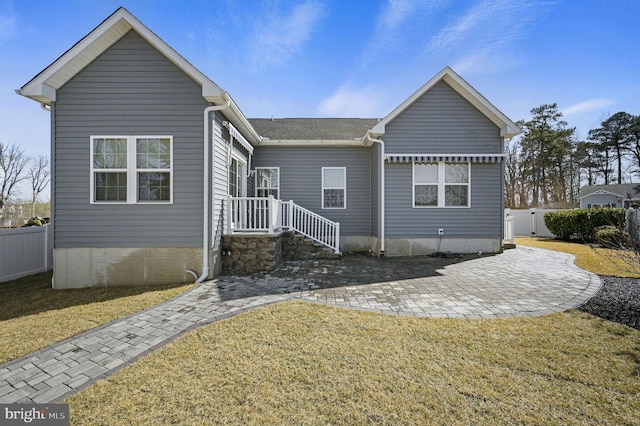 rear view of property with a patio area, a lawn, and fence