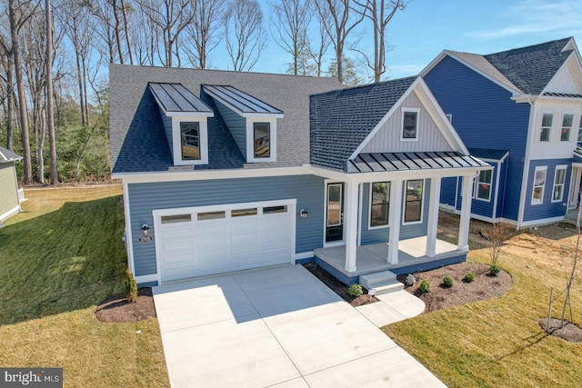 modern inspired farmhouse with a porch, concrete driveway, a front yard, metal roof, and a standing seam roof