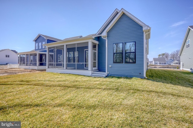 rear view of property with a lawn and a sunroom