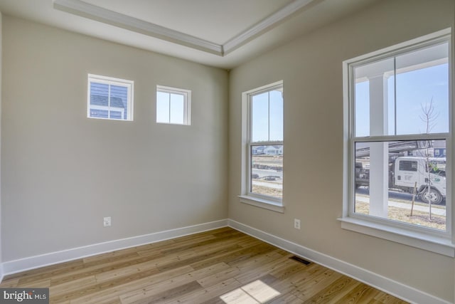 unfurnished room with plenty of natural light, baseboards, and light wood finished floors