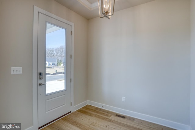 entryway featuring visible vents, baseboards, light wood-style floors, and a chandelier