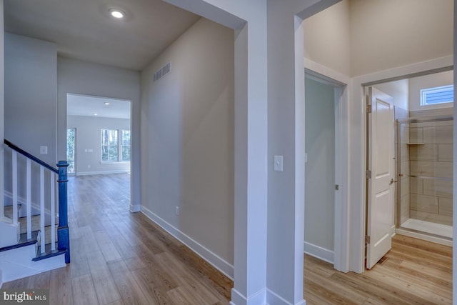 hall with visible vents, baseboards, stairs, recessed lighting, and wood finished floors