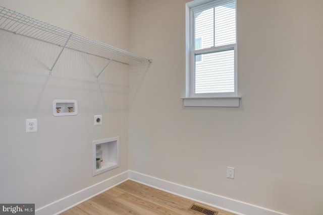 clothes washing area with baseboards, visible vents, hookup for an electric dryer, laundry area, and washer hookup