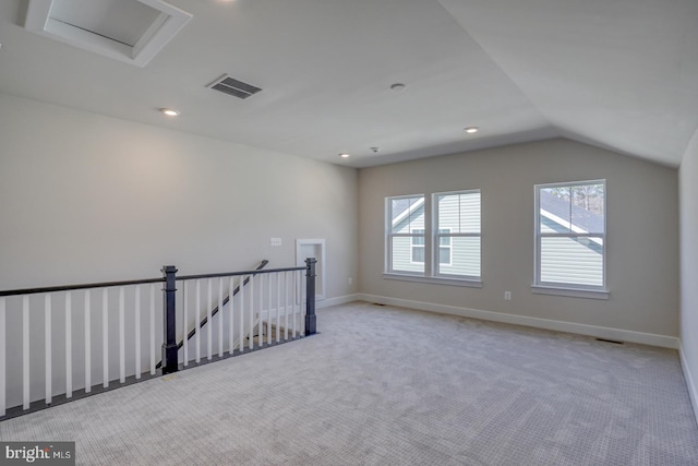 empty room featuring visible vents, baseboards, carpet, and lofted ceiling