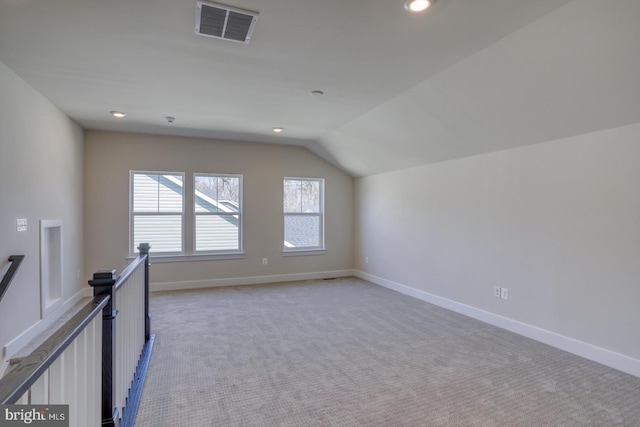 additional living space featuring visible vents, baseboards, light colored carpet, lofted ceiling, and recessed lighting