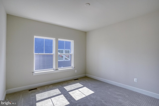 unfurnished room featuring carpet flooring, baseboards, and visible vents