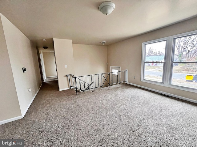 unfurnished room with visible vents, baseboards, and carpet floors