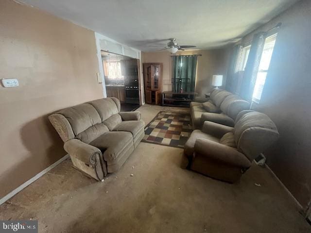 living room with baseboards, a healthy amount of sunlight, and ceiling fan