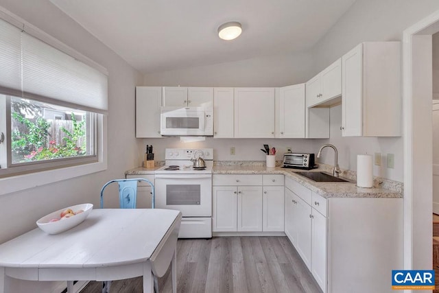 kitchen with a sink, white appliances, light wood-style flooring, and white cabinetry