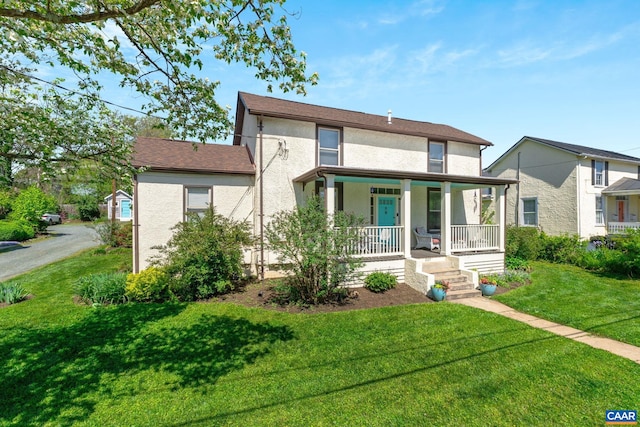 view of front of home featuring stucco siding, covered porch, and a front yard