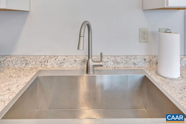 interior details featuring white cabinets, light countertops, and a sink