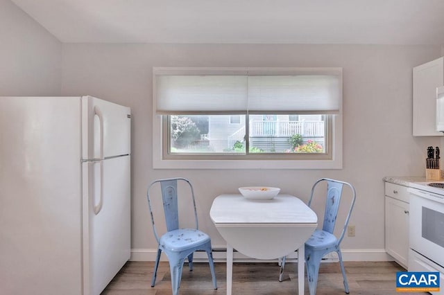 dining room featuring light wood finished floors and baseboards