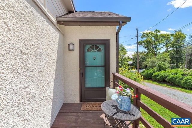 doorway to property featuring a balcony and stucco siding