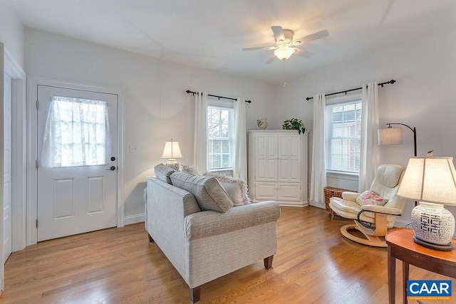 living room featuring light wood-style flooring, plenty of natural light, and ceiling fan