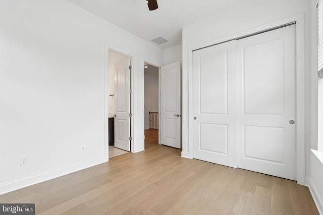 unfurnished bedroom featuring light wood finished floors, visible vents, baseboards, and a closet