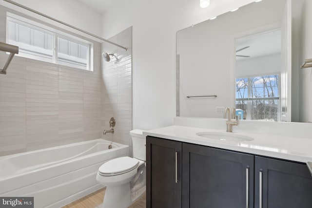 full bath featuring vanity, bathing tub / shower combination, toilet, and a healthy amount of sunlight