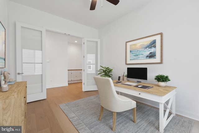 home office with light wood-style flooring, baseboards, and ceiling fan