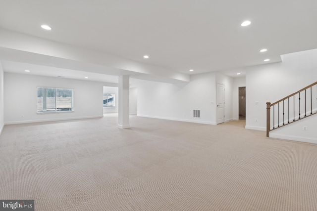 basement featuring visible vents, recessed lighting, stairway, baseboards, and light colored carpet