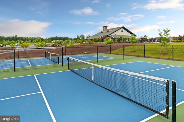 view of tennis court with community basketball court and fence