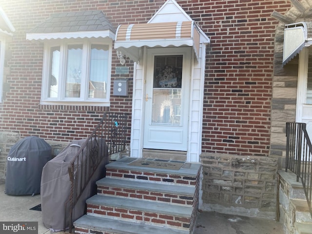 view of exterior entry with brick siding