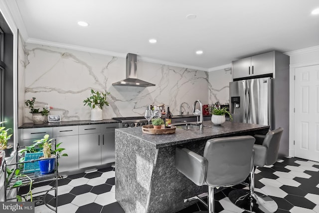 kitchen featuring appliances with stainless steel finishes, wall chimney exhaust hood, dark floors, and a sink