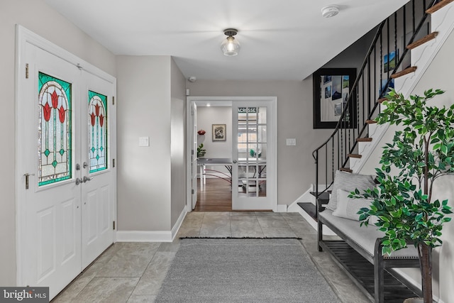 entrance foyer with french doors, baseboards, and stairway