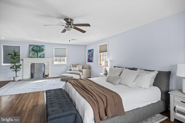 bedroom featuring visible vents, a ceiling fan, dark wood-type flooring, and baseboards