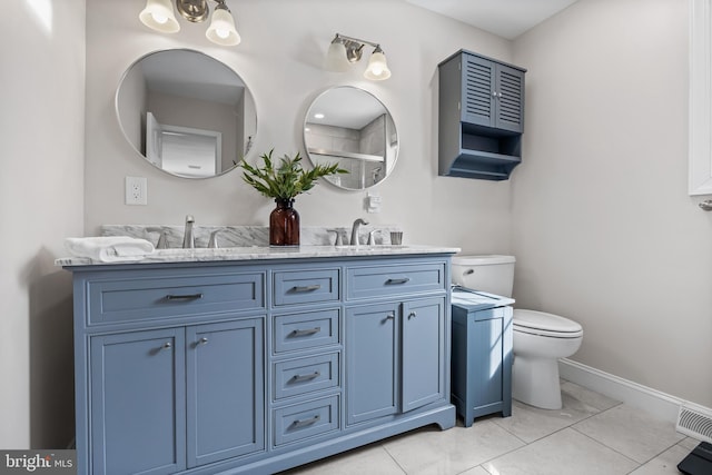 bathroom featuring double vanity, toilet, baseboards, and a sink