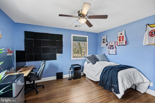 bedroom featuring visible vents, baseboards, wood finished floors, and a ceiling fan