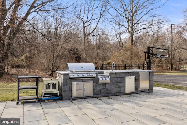 view of patio with a sink, a grill, an outdoor kitchen, and fence